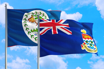 Cayman Islands and Belize national flag waving in the windy deep blue sky. Diplomacy and international relations concept.