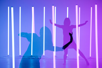 Collage from shadows young woman dancer dancing and posing in a room with neon lamps. A slender modern model on a purple blue background.