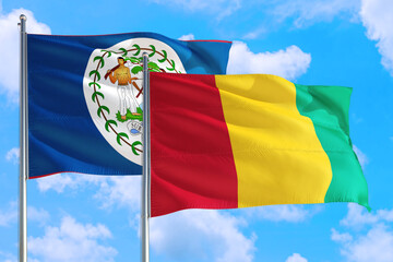 Guinea Bissau and Belize national flag waving in the windy deep blue sky. Diplomacy and international relations concept.