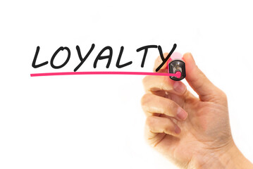 the hand writes the word loyalty with a marker on a white background. business concept