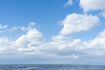 Naklejka na ściany i meble Blue sky with fluffy clouds over the sea in springtime, Seascape of blue ocean in sunnyday summer. Beautiful natural horizon for holiday background concept.
