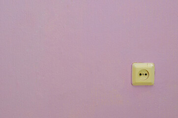 Electrical outlet on the wall, with pink Wallpaper