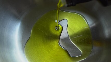 Pouring olive oil into a frying pan..Close up of Pouring vegetable oil into a wok. - Powered by Adobe