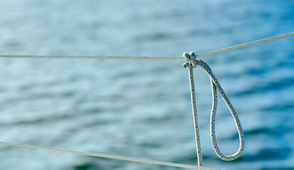 Knot on the fence of the yacht board against the background of the ocean sea water