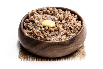 Boiled buckwheat with butter in wooden bowl isolated on white
