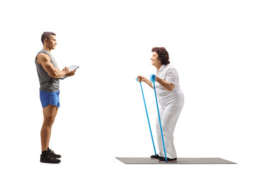 Fitness instructor and an elderly woman exercising with a resistance band