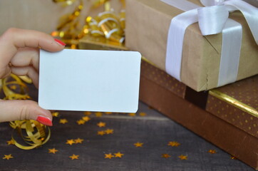 Female hands holding credit card or gift certificate smart mobile phone, tablet Christmas gifts, golden serpentine stars celebrate the holiday, party. Happy New Year Flat lay top view online shopping