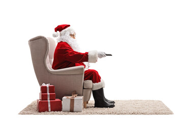 Santa claus sitting in an armchair and holding a remote control
