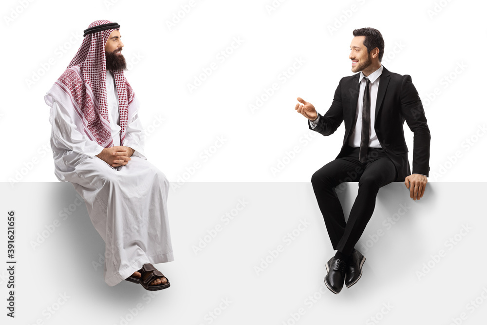 Wall mural Saudi arab man talking to a businessman in a suit and sitting on a blank panel