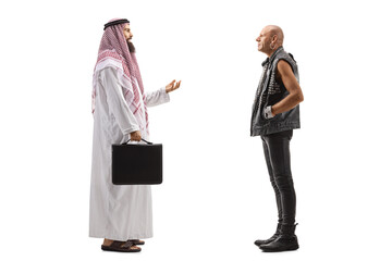 Saudi arab man talking to a bald punk in leather clothing