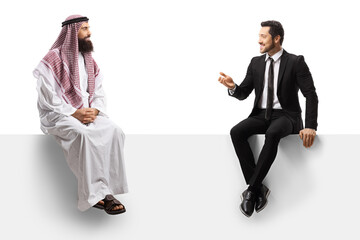 Saudi arab man talking to a businessman in a suit and sitting on a blank panel