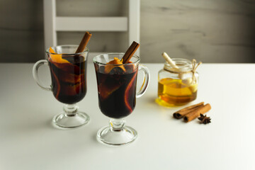 Mulled wine with cinnamon sticks, orange slices and honey