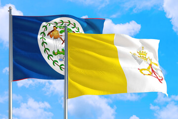 Vatican City and Belize national flag waving in the windy deep blue sky. Diplomacy and international relations concept.