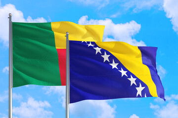Bosnia Herzegovina and Benin national flag waving in the windy deep blue sky. Diplomacy and international relations concept.