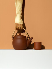 Hand holding Clay teapot minimal still life concept. Winter warm time