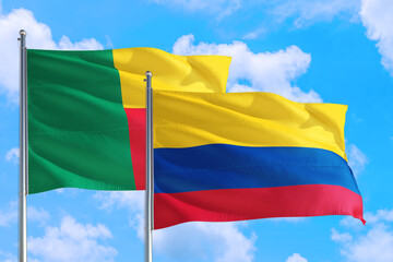 Colombia and Benin national flag waving in the windy deep blue sky. Diplomacy and international relations concept.