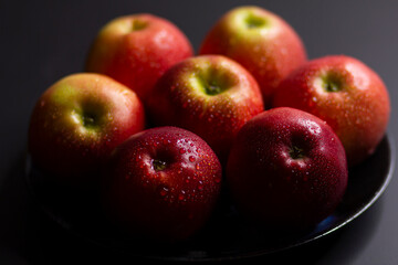 Large ripe red apples on a dark background, close-up.
