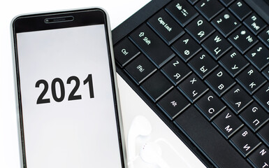 Text 2021 on the phone that is on the laptop keyboard. Financial concept