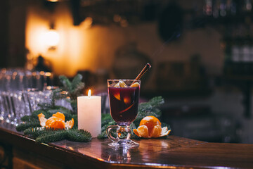 Red hot drink glintwein with spices, cinnamon, anise, fruits, brown sugar on an old wooden table. New Year and Christmas holidays concept. Mulled wine and glintwein.