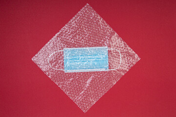 blue mouthguard under a plastic bubble wrap on a red background