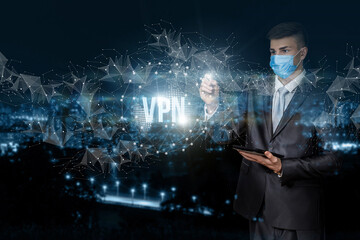 Obraz na płótnie Canvas Businessman works with a private virtual network against the background of a night city.