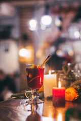 Red hot drink glintwein with spices, cinnamon, anise, fruits, brown sugar on an old wooden table. New Year and Christmas holidays concept. Mulled wine and glintwein.