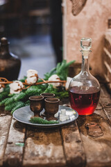 Christmas vintage background, craft alcohol drink and ancient dishes, fluffy fir branches and festive decor.