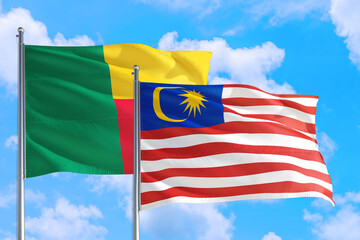 Malaysia and Benin national flag waving in the windy deep blue sky. Diplomacy and international relations concept.