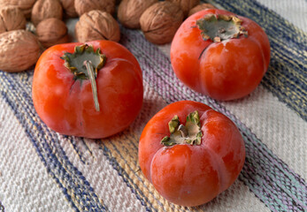 Ripe orange persimmons lie on wooden planks.