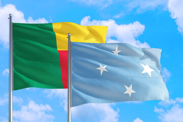 Micronesia and Benin national flag waving in the windy deep blue sky. Diplomacy and international relations concept.