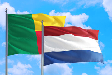 Netherlands and Benin national flag waving in the windy deep blue sky. Diplomacy and international relations concept.