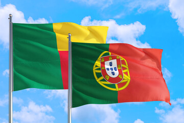 Portugal and Benin national flag waving in the windy deep blue sky. Diplomacy and international relations concept.