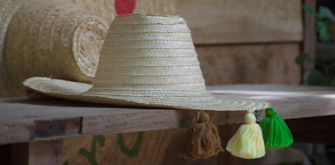 Closeup of a straw hat with colorful tassels on a wooden table