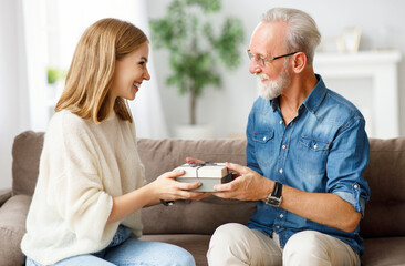Happy woman giving present to father.