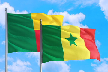 Senegal and Benin national flag waving in the windy deep blue sky. Diplomacy and international relations concept.