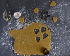 raw dough for baking, christmas cookies, heart shaped cookies, ingredients in the background flat...