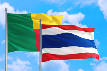 Thailand and Benin national flag waving in the windy deep blue sky. Diplomacy and international relations concept.