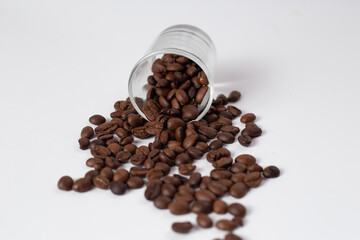 Brown coffee beans pour out on white table
