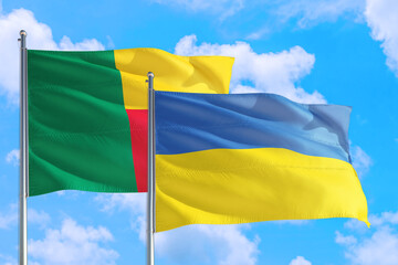 Ukraine and Benin national flag waving in the windy deep blue sky. Diplomacy and international relations concept.