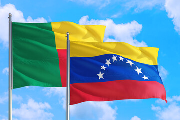 Venezuela and Benin national flag waving in the windy deep blue sky. Diplomacy and international relations concept.