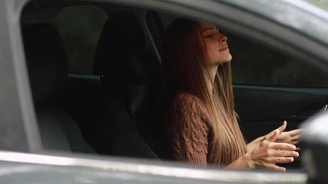 driving, safety and people concept - The girl drives a car, she is in a good mood, she sings and dances. 4k