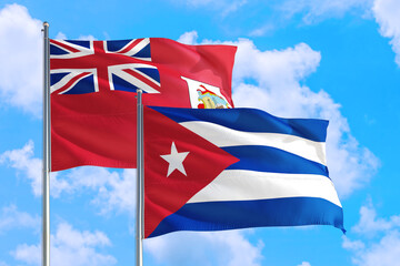 Cuba and Bermuda national flag waving in the windy deep blue sky. Diplomacy and international relations concept.