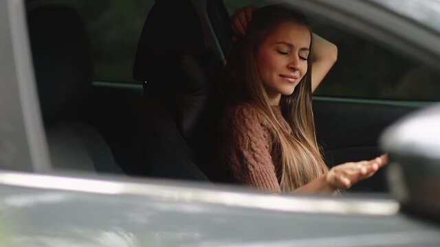 driving, safety and people concept - The girl drives a car, she is in a good mood, she sings and dances. 4k