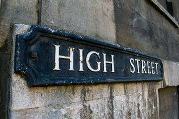 High Street sign in Oxford, black street name paque with white letters, High Streets are often considered to be the most expensive street in the city, with many designer shops and posh restaurants.