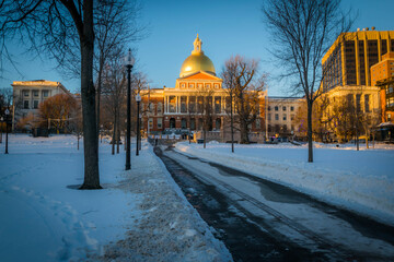 A snowy Boston Common looking up at the golden dome of the State House