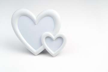 Background for February 14, frame of two white hearts on a light background. Side view with space for copying. Concept for lovers.