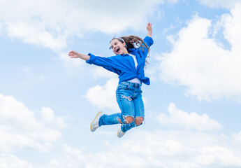 Fototapeta na wymiar Fashion is her life. teen girl jumping high in the sky. having a party fun. Happy kid wear shirt. Lifestyle and People Concept. kid spring and fall fashion. full of energy. childhood happiness