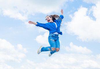 Obraz premium Fashion is her life. teen girl jumping high in the sky. having a party fun. Happy kid wear shirt. Lifestyle and People Concept. kid spring and fall fashion. full of energy. childhood happiness