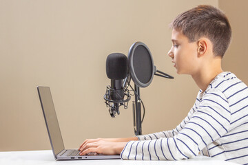 Kid with laptop computer talking into microphone. Techology, online learning, remote education,...