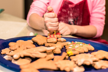 Fototapeta na wymiar christmas gingerbread biscuits beeing adorned